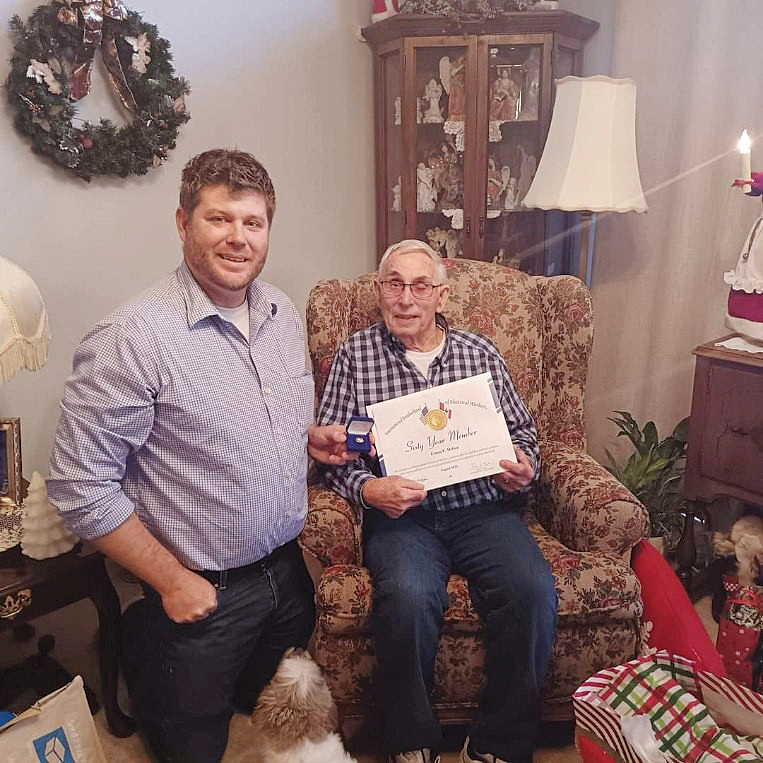 Local 71 President Walter Gribble III presents a 60-year service pin to his grandfather, Ernie McGee.