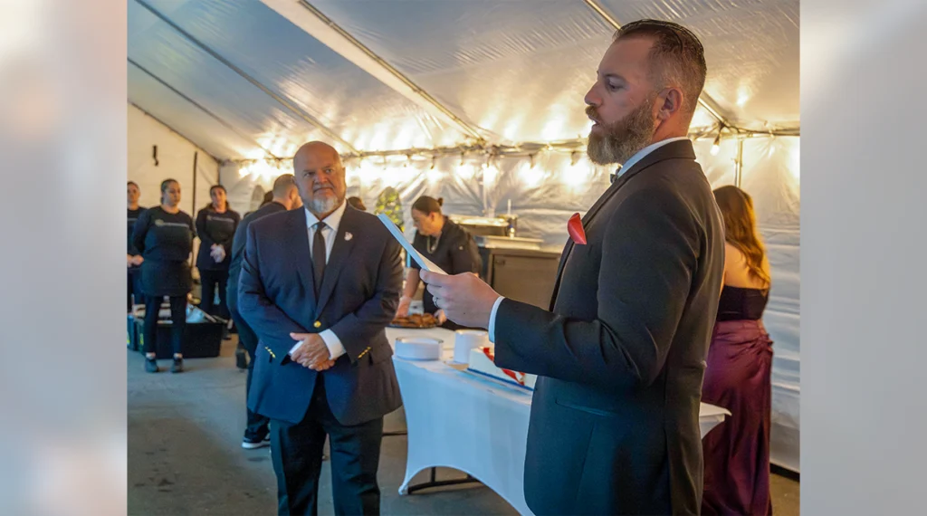Local 1245 Business Manager Bob Dean, a Navy veteran, listens as Business Representative Mike Tilden, a Marine Corps veteran, speaks during the local’s inaugural veterans gala.