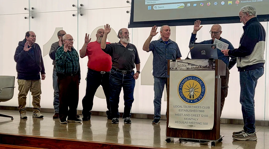 Local 134 executive board member Bob Pitlock swearing in the newly elected officers and board member at the March meeting.